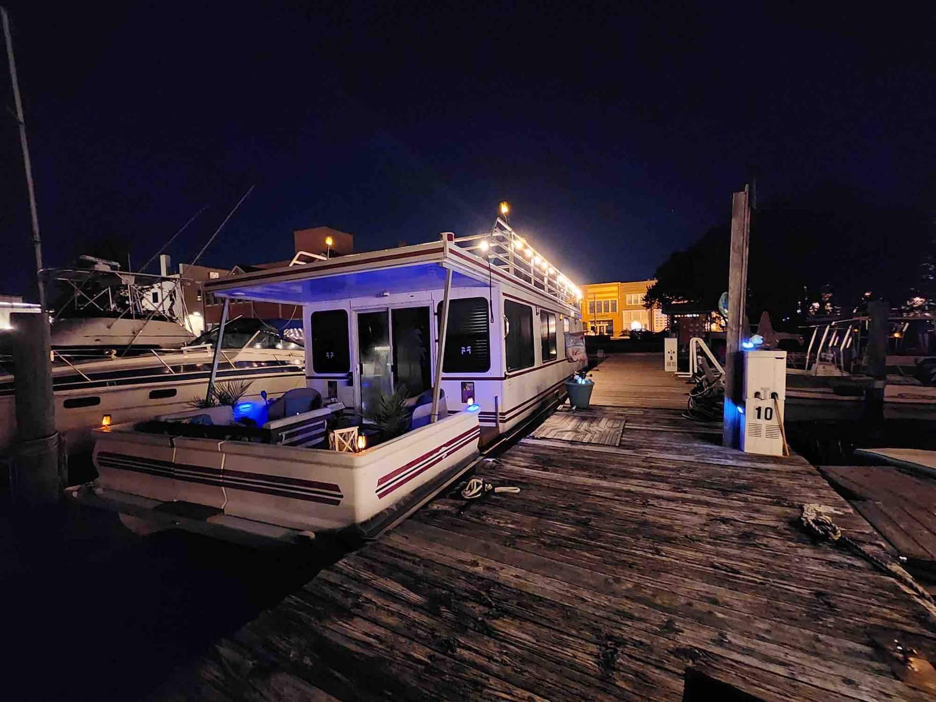 Island Time houseboat glowing at its downtown Elizabeth City marina slip at night